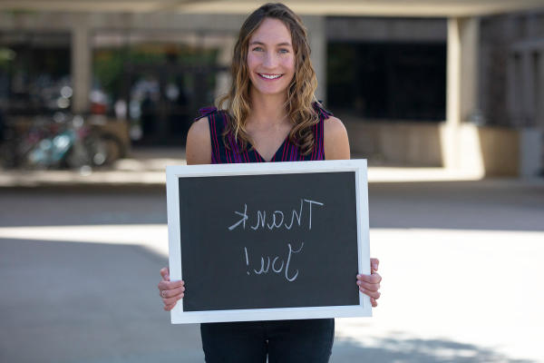 student holding chalkboard saying "thank you"